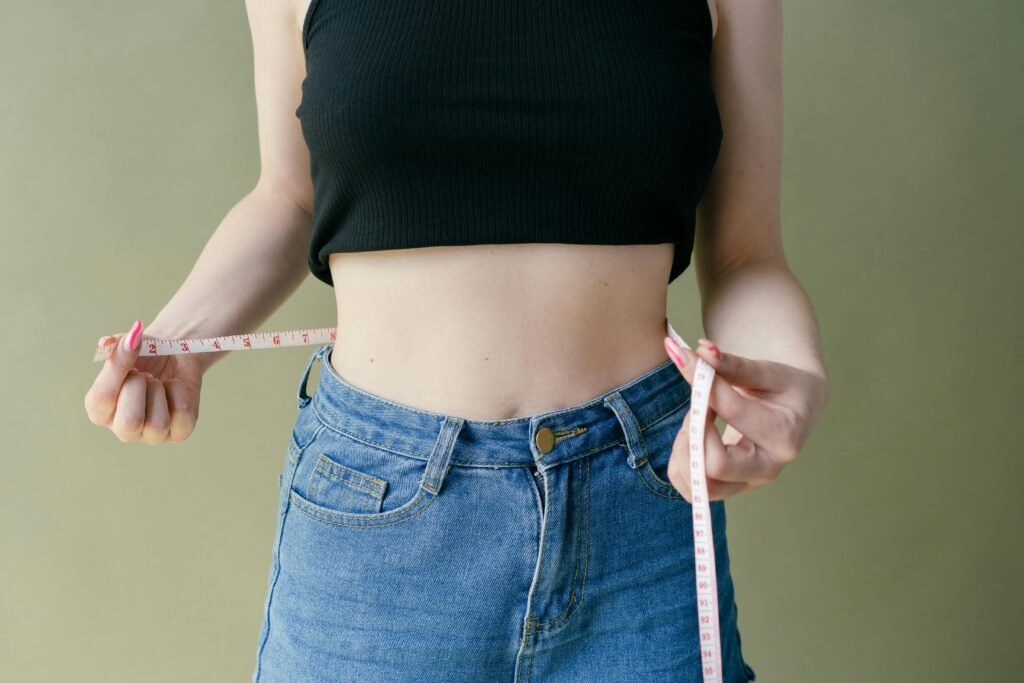 Person tracking weight loss progress with a measuring tape over 90 days