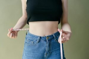 Person tracking weight loss progress with a measuring tape over 90 days